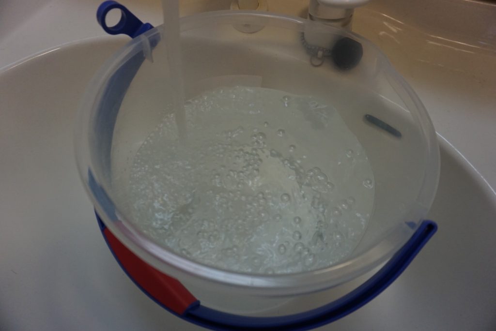 プロアマットを洗うためにバケツに水を汲む